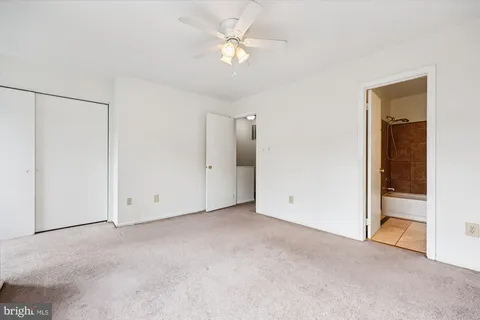an empty room with a ceiling fan and a window