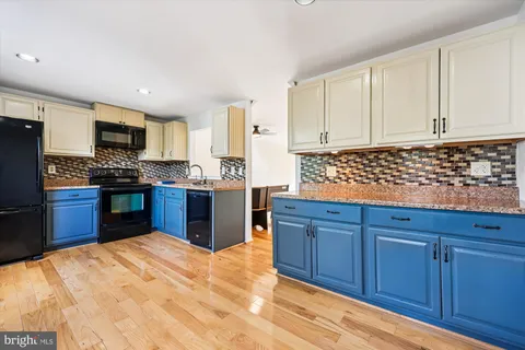 a kitchen with stainless steel appliances granite countertop wooden cabinets a stove top oven a sink and dishwasher