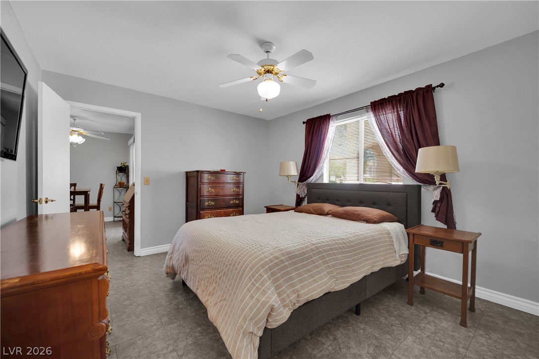 7570 West Flamingo Road, Unit 115 Las Vegas, NV 89147 - Photo 17 of 34 Relax in this well-lit bedroom featuring a ceiling fan and tiled flooring.