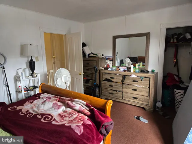 a bedroom with a bed and a flat tv screen on dresser
