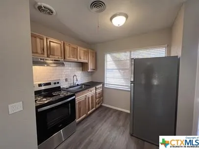 a kitchen with stainless steel appliances granite countertop a stove and a refrigerator