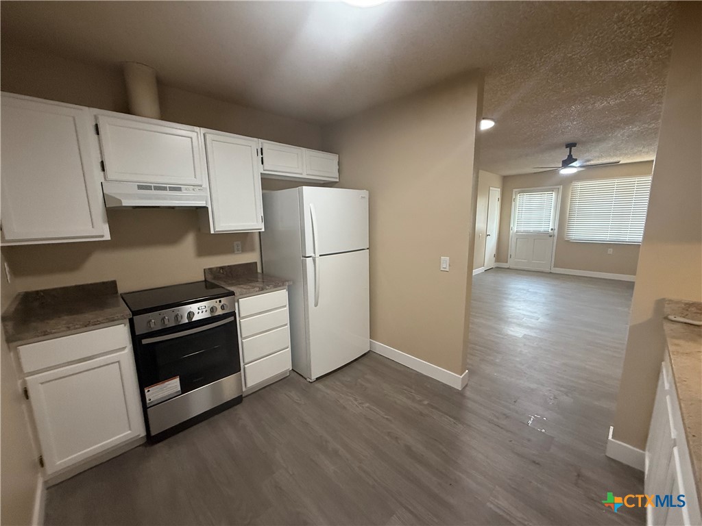 200 Olsens Acres, Unit C2 Wimberley, TX 78676 - Photo 8 of 16 a kitchen with granite countertop white cabinets and stainless steel appliances