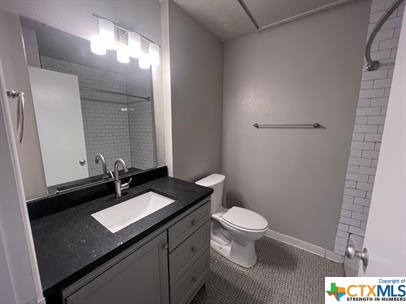 200 Olsens Acres, Unit D6 Wimberley, TX 78676 - Photo 10 of 21 a bathroom with a granite countertop sink toilet and a mirror