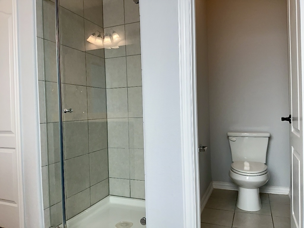 209 Penna Lane Georgetown, TX 78628 - Photo 10 of 19 a bathroom with a toilet and a shower