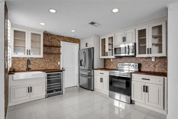 a kitchen with stainless steel appliances granite countertop a stove sink and cabinets