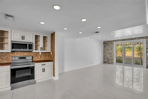 a view of kitchen with stainless steel appliances kitchen island granite countertop a stove and a sink