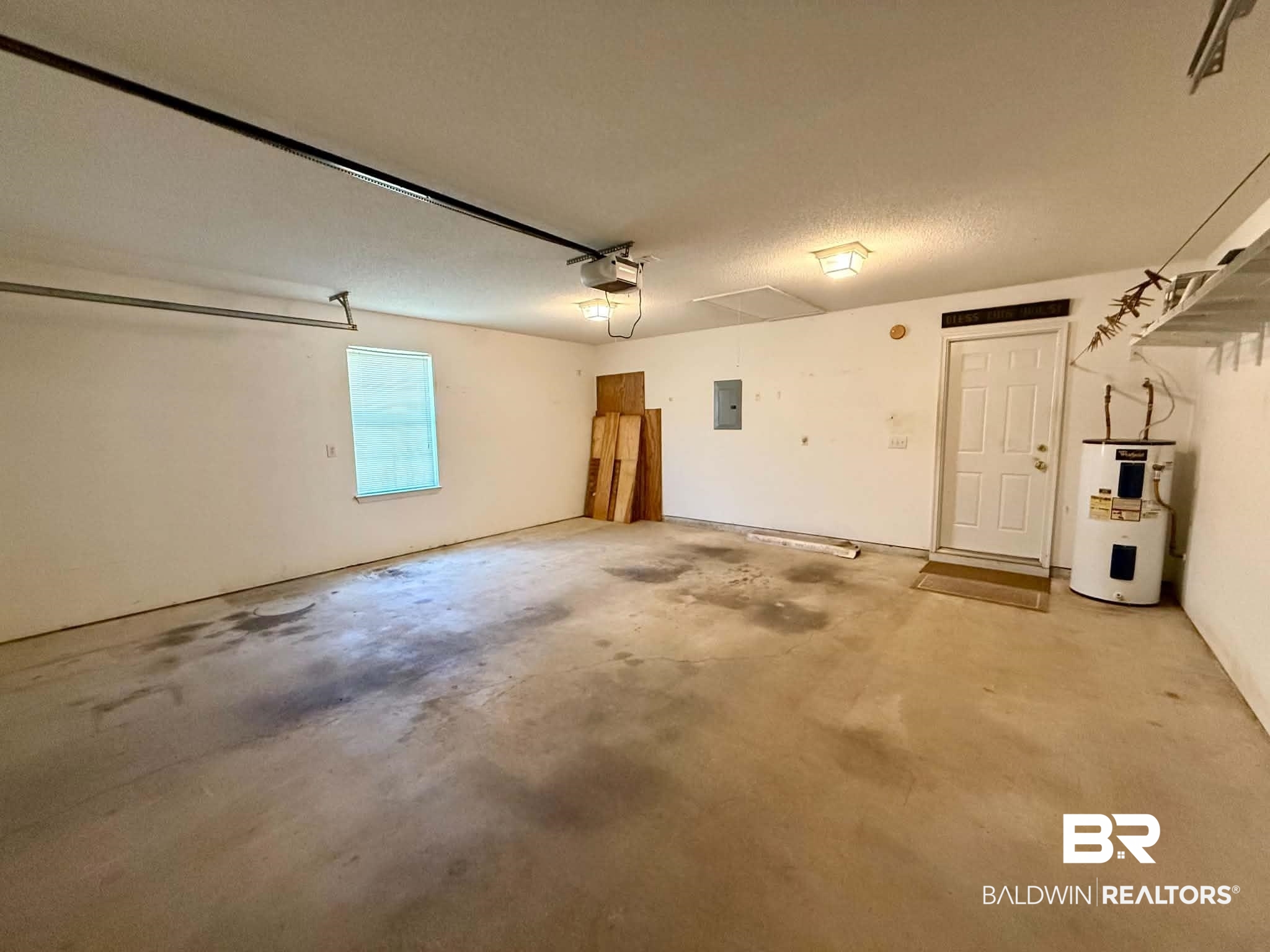 123 Pennbrooke Loop Foley, AL 36535 - Photo 49 of 49 Spacious garage featuring a concrete floor, overhead lighting, a single window with blinds, and a utility door
