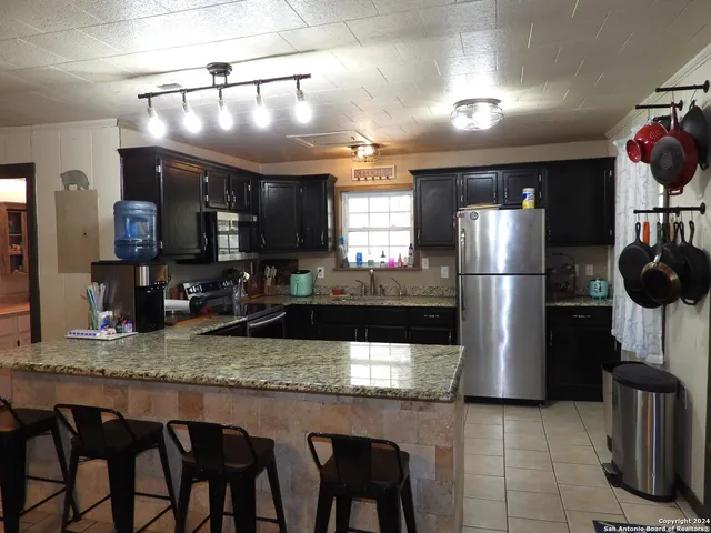 a kitchen with stainless steel appliances granite countertop a refrigerator and a sink