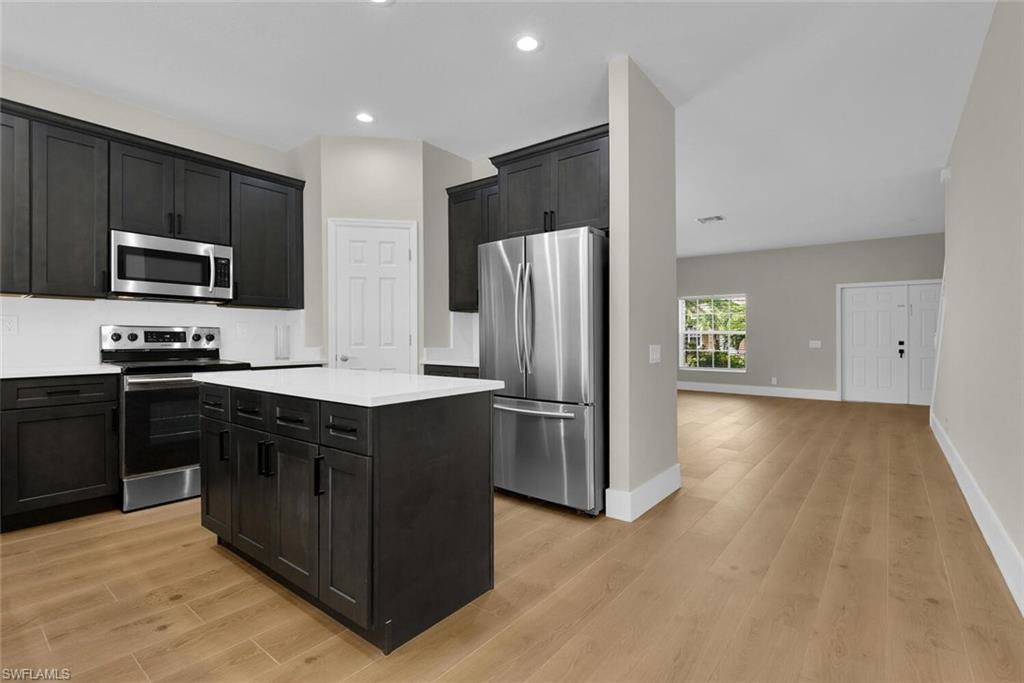 8883 Falcon Pointe Loop Fort Myers, FL 33912 - Photo 14 of 49 a kitchen with stainless steel appliances granite countertop a refrigerator and a stove top oven