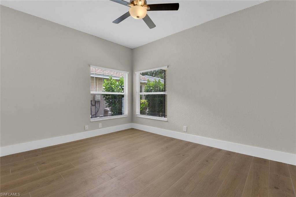 8883 Falcon Pointe Loop Fort Myers, FL 33912 - Photo 17 of 49 a view of an empty room with wooden floor and a window