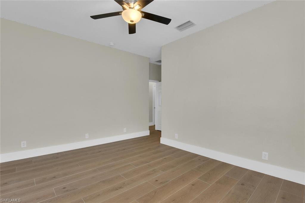 8883 Falcon Pointe Loop Fort Myers, FL 33912 - Photo 18 of 49 a view of an empty room with wooden floor
