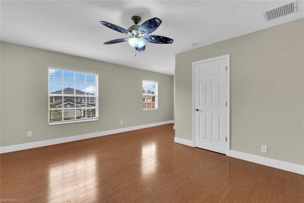 8883 Falcon Pointe Loop Fort Myers, FL 33912 - Photo 39 of 49 a view of an empty room with a window and wooden floor