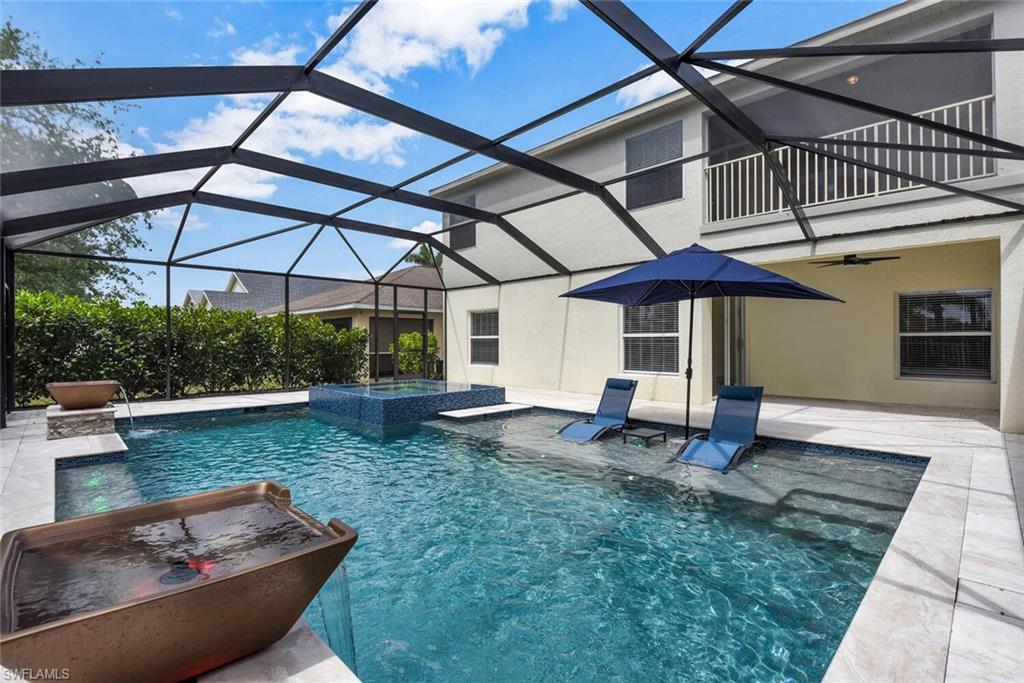 8883 Falcon Pointe Loop Fort Myers, FL 33912 - Photo 7 of 49 a view of a backyard with table and chairs under an umbrella