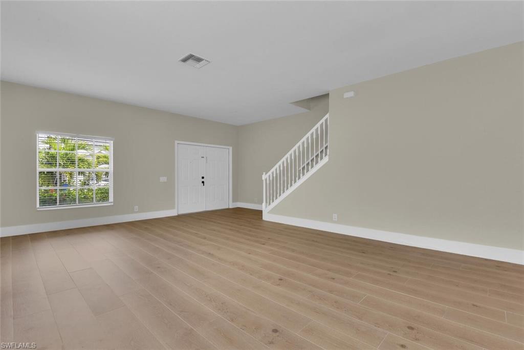 8883 Falcon Pointe Loop Fort Myers, FL 33912 - Photo 8 of 49 a view of an empty room with wooden floor and a window
