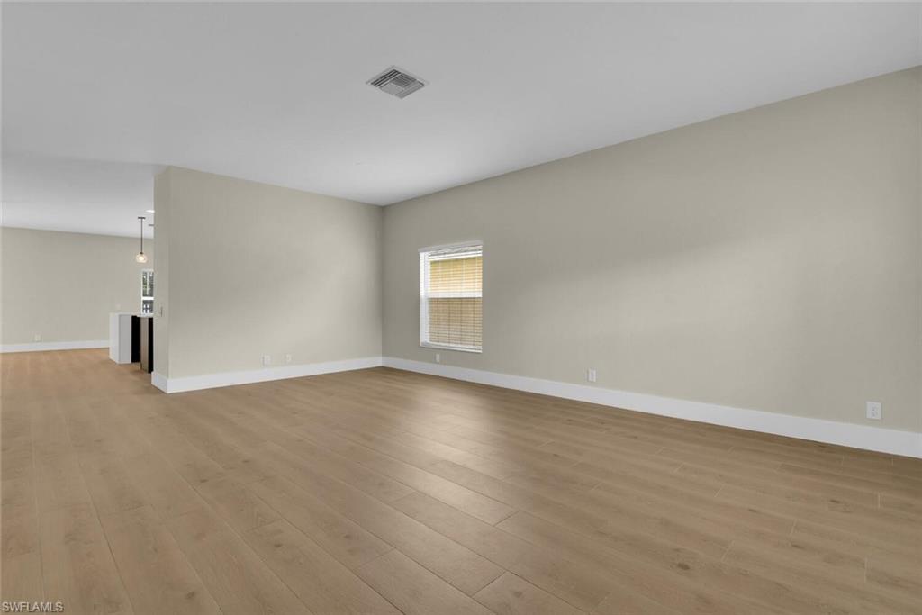 8883 Falcon Pointe Loop Fort Myers, FL 33912 - Photo 10 of 49 a view of an empty room with wooden floor and window