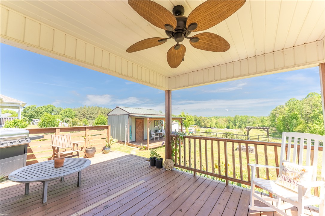 696 Mt Olivet Road Six Mile, SC 29682 - Photo 21 of 35 This spacious wooden deck offers expansive views of a tranquil rural landscape under an open sky.