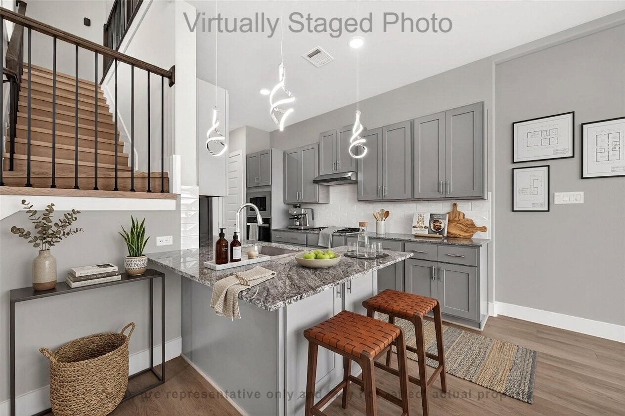 10719 Mason Road, Unit 39 Richmond, TX 77406 - Photo 8 of 50 Virtual Staging - Open-concept kitchen featuring grey cabinetry, granite countertops, a small peninsula with woven leather stools, and striking spiral pendant lights