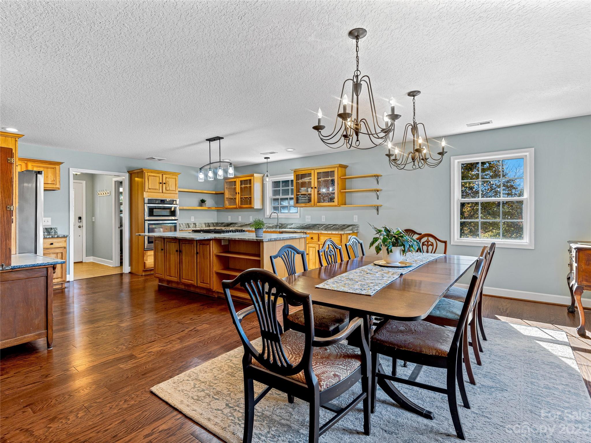 263 Sylvan Lane Mill Spring, NC 28756 - Photo 15 of 45 a view of a dining room with furniture wooden floor and chandelier