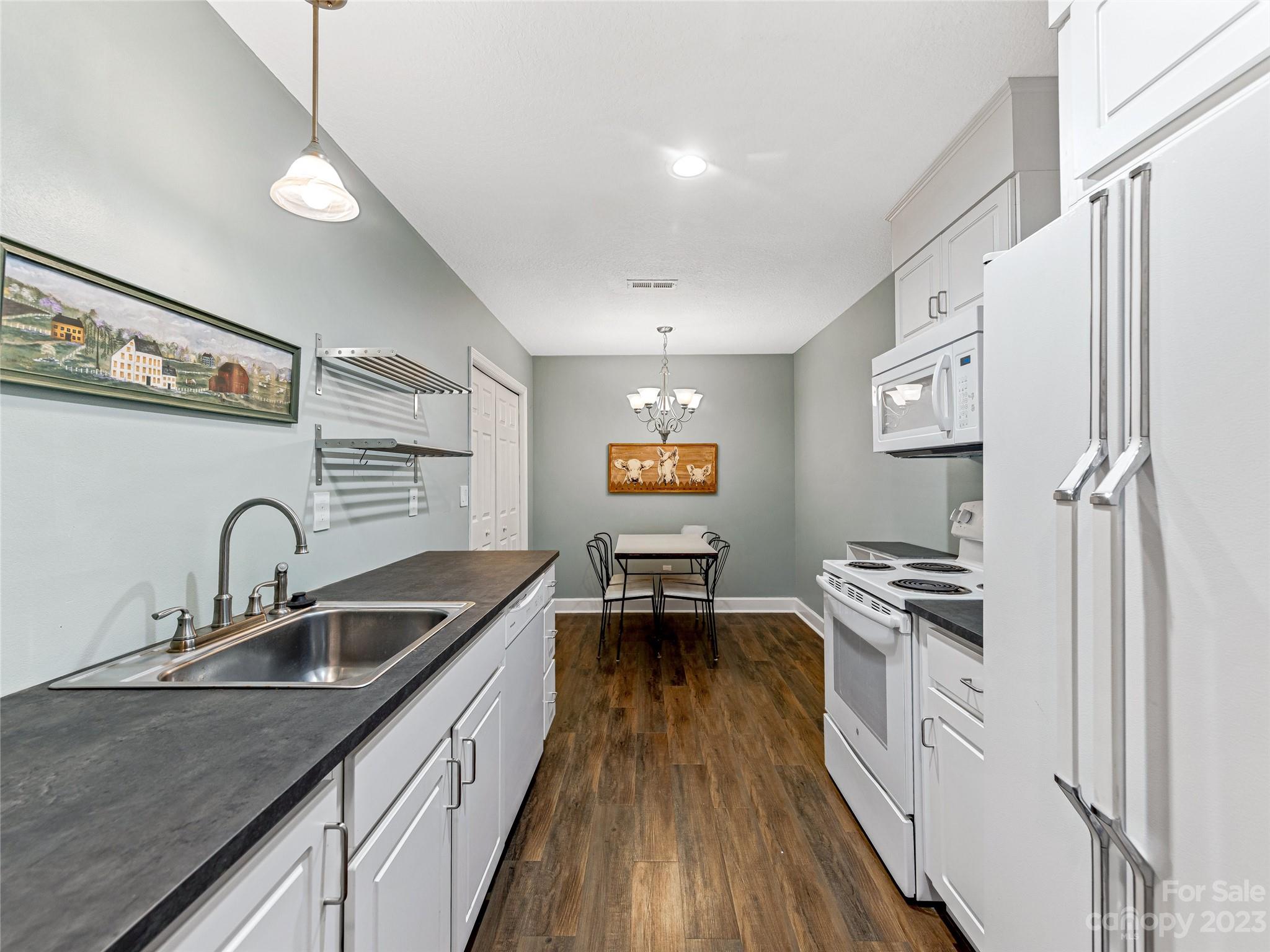 263 Sylvan Lane Mill Spring, NC 28756 - Photo 24 of 45 a kitchen with granite countertop a sink stove and refrigerator