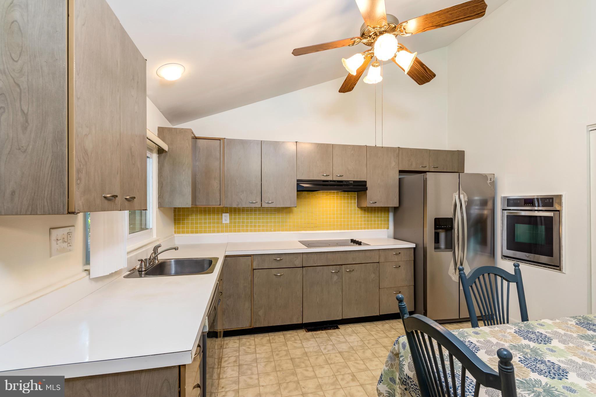 7434 Ricksway Road Pikesville, MD 21208 - Photo 16 of 30 a kitchen with stainless steel appliances a sink a stove and a refrigerator