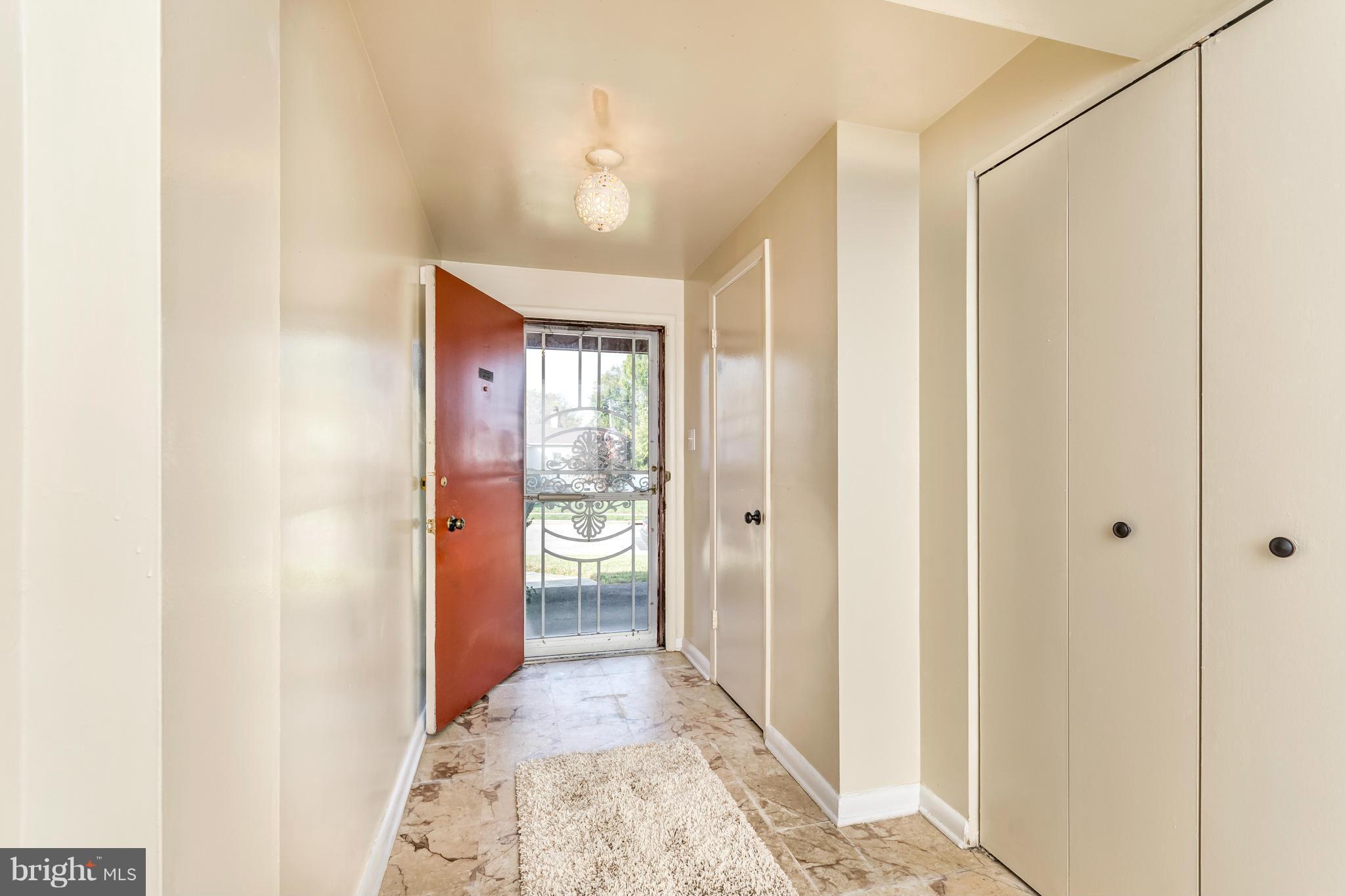 7434 Ricksway Road Pikesville, MD 21208 - Photo 6 of 30 a view of hallway with a chandelier and a glass door