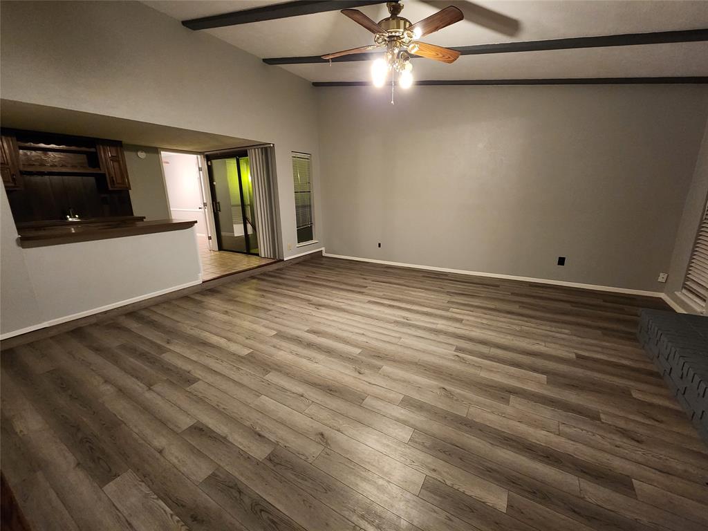 5604 Usher Street The Colony, TX 75056 - Photo 24 of 30 an empty room with wooden floor fan and windows