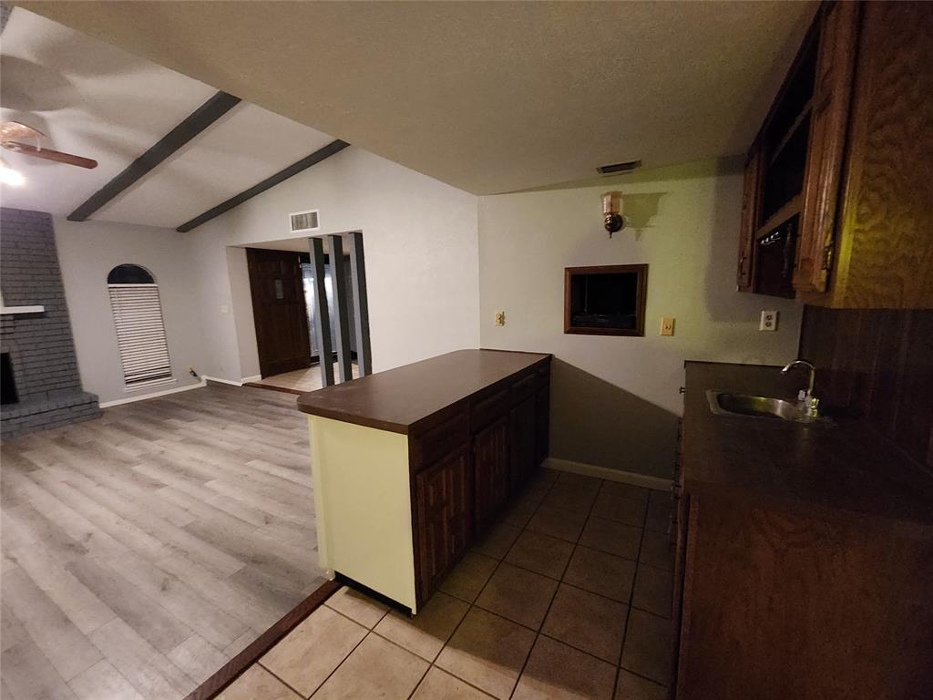 5604 Usher Street The Colony, TX 75056 - Photo 25 of 30 a kitchen with kitchen island granite countertop a sink and cabinets