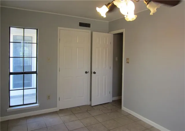 an empty room with windows and cabinet