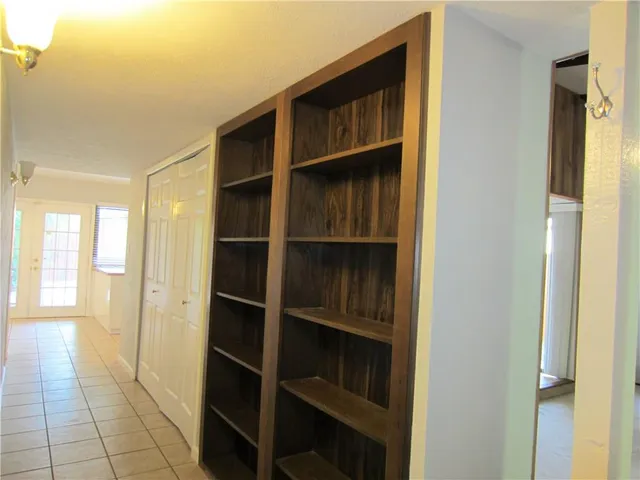 a view of an empty room with cabinet and a window