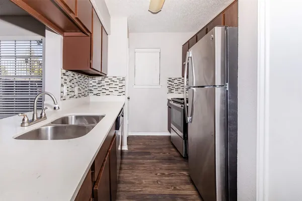 a kitchen with kitchen island granite countertop a sink and refrigerator