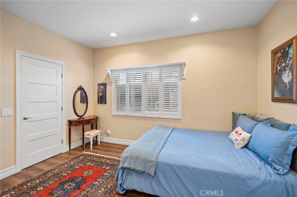 3 Snowdon Rancho Santa Margarita, CA 92679 - Photo 42 of 69 a bedroom with a bed a desk and chair with wooden floor