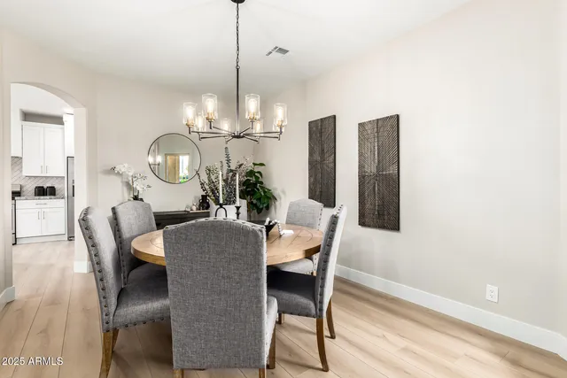 a kitchen with stainless steel appliances kitchen island granite countertop a stove a sink a refrigerator a center island with a dining table and chairs