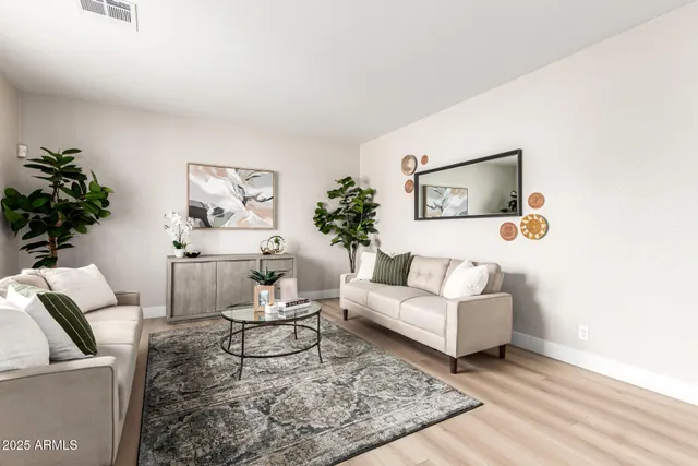 a living room with furniture a fireplace and a large window with wooden floor