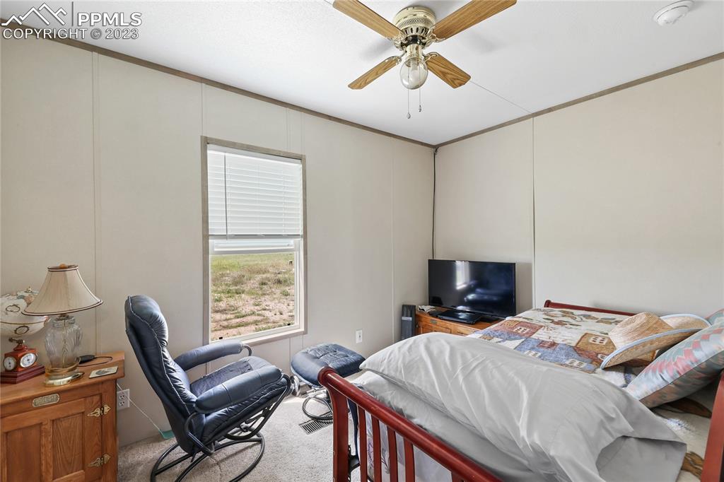 10845 Berridge Road Calhan, CO 80808 - Photo 17 of 32 a bedroom with a bed and a chandelier