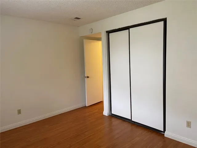 an empty room with wooden floor and entrance