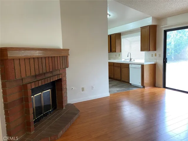 a view of an empty room with a fireplace and a window