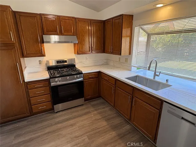 a kitchen with stainless steel appliances a stove a sink and a refrigerator