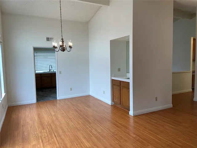 an empty room with wooden floor and ceiling fan
