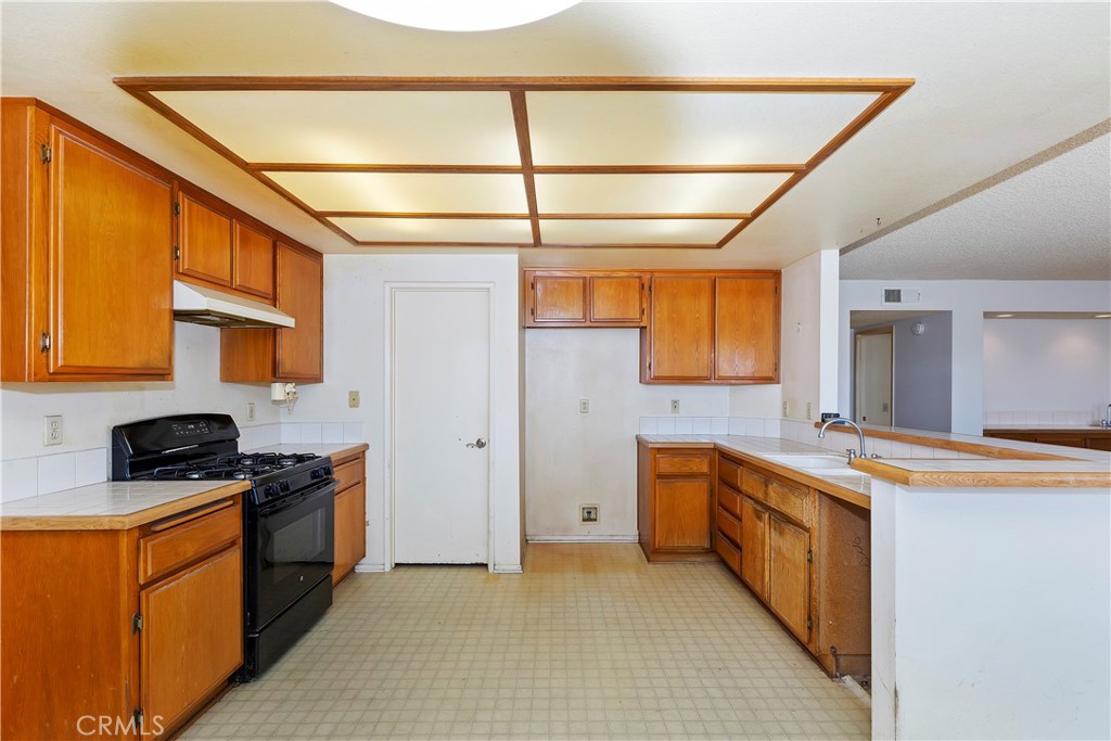 15620 Smoke Tree Street Hesperia, CA 92345 - Photo 12 of 34 a kitchen with stainless steel appliances granite countertop a stove a sink and a refrigerator