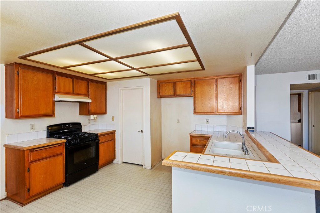15620 Smoke Tree Street Hesperia, CA 92345 - Photo 13 of 34 a kitchen with stainless steel appliances granite countertop a sink and cabinets