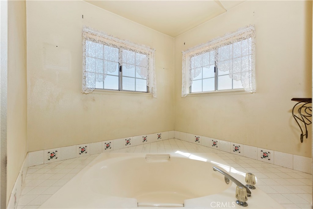 15620 Smoke Tree Street Hesperia, CA 92345 - Photo 28 of 34 a bathroom with a tub sink and mirror
