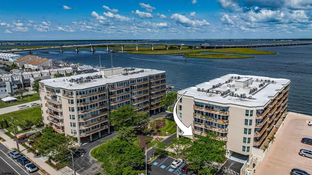 a view of a big building with swimming pool and lawn chairs