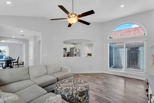 a living room with furniture and a flat screen tv with kitchen view