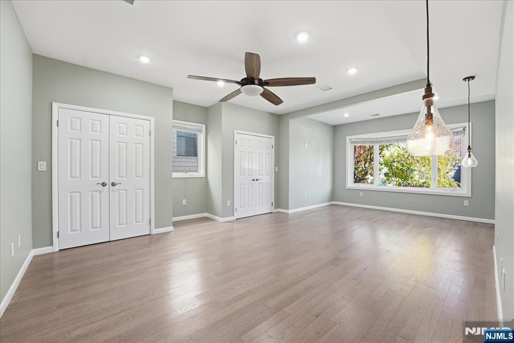 85 Beckwith Place, Unit 1 Rutherford, NJ 07070 - Photo 2 of 20 an empty room with wooden floor fan and windows