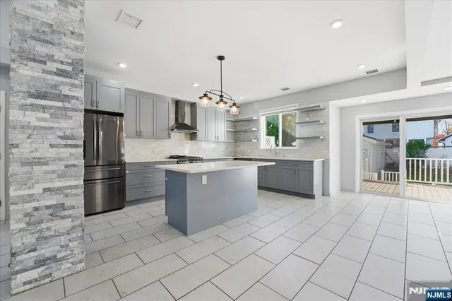 a large kitchen with granite countertop a stove a sink dishwasher and a refrigerator