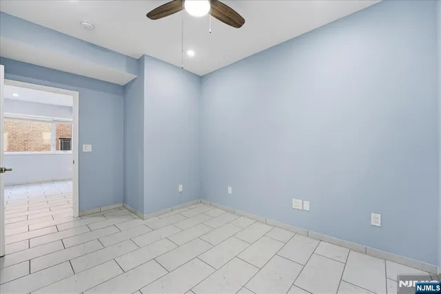 an empty room and chandelier fan