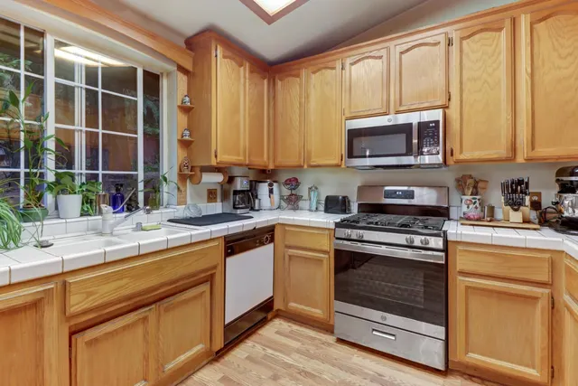 a kitchen with granite countertop cabinets stainless steel appliances and a sink