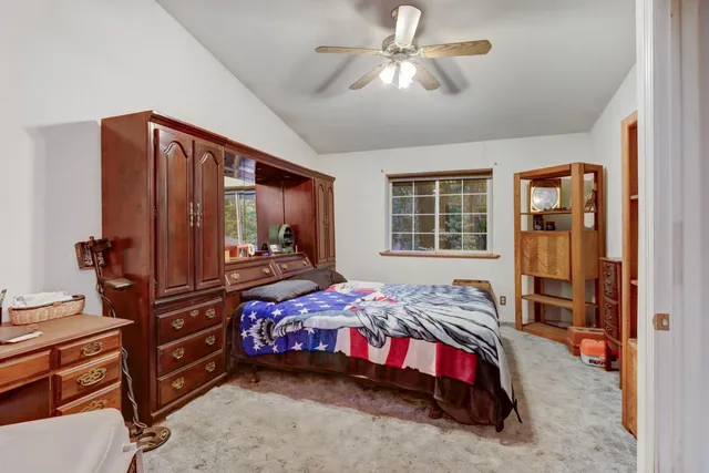 a bedroom with a bed and large windows