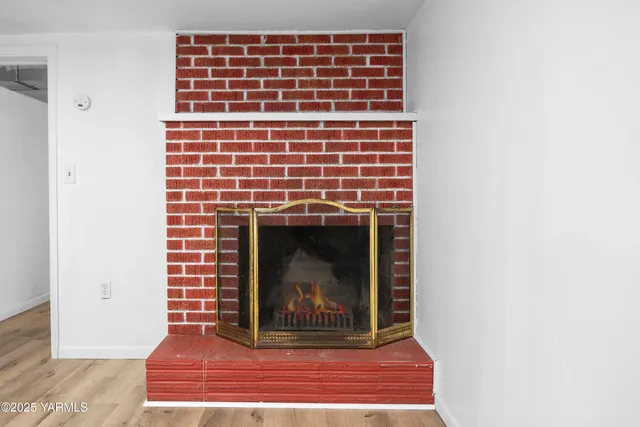 a view of an empty room with wooden floor and closet
