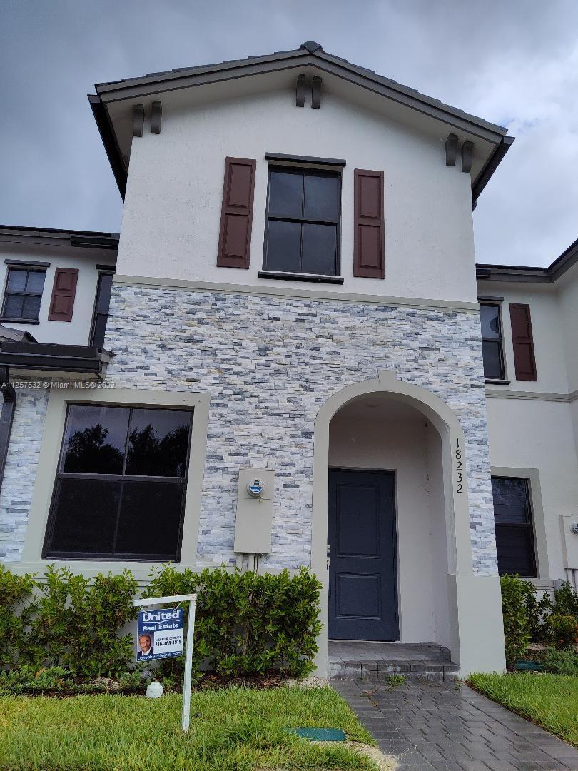 a front view of a house with plants